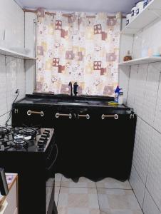a kitchen with a sink and a stove at casa 1 perto do pavilhão de Carapina a 8 kilometros do aeroporto in Serra +13 photos