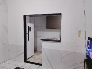 a small bathroom with a refrigerator and a mirror at casa 1 perto do pavilhão de Carapina a 8 kilometros do aeroporto in Serra