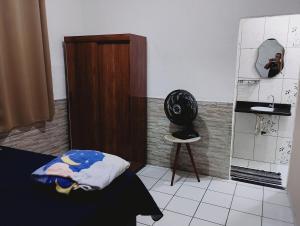 a room with a bed and a mirror and a chair at casa 1 perto do pavilhão de Carapina a 8 kilometros do aeroporto in Serra