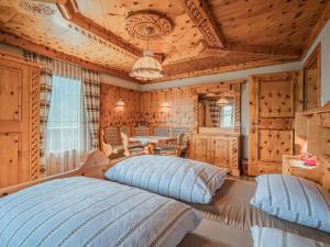 two beds in a room with wooden walls at Poschen in Wald im Pinzgau