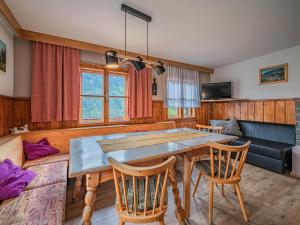 a dining room with a table and chairs and a couch at Poschen in Wald im Pinzgau