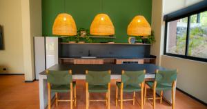 a kitchen with a table with chairs and a refrigerator at BEE Suites Santa Ana - San Jose in San José