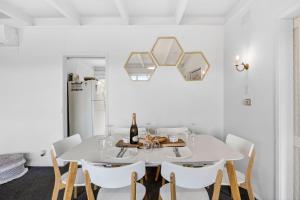 a white dining room with a white table and chairs at Oceanside Escape in Aireys Inlet