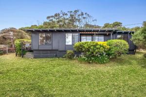 a black house with a green yard at Oceanside Escape in Aireys Inlet