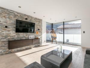 a living room with a tv on a brick wall at Alpin Chalet ARTE in Söll