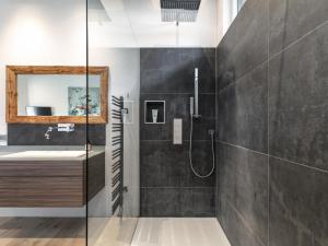 a bathroom with a shower and a sink at Alpin Chalet ARTE in Söll +32 photos