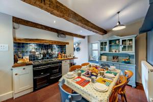 a kitchen with blue cabinets and a table with chairs at 3 Bed in Ruthin oc-a29313 in Ruthin