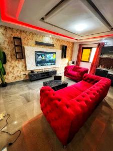 a living room with a red couch and a tv at Kantora Red almadie in Dakar