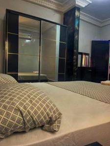 a bedroom with a bed with a large glass closet at Kantora Red almadie in Dakar