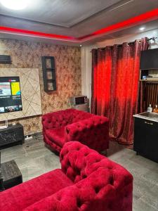 a living room with a red couch and a tv at Kantora Red almadie in Dakar +3 photos