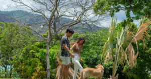 a man and a woman standing next to a dog at BEE Suites Santa Ana - San Jose in San José