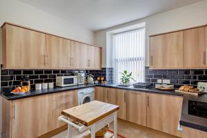 a large kitchen with wooden cabinets and a table at 3 Bed in Llanbedr oc-t28932 in Llanbedr