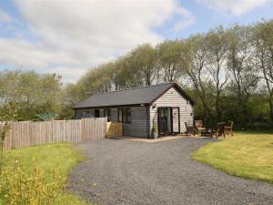 a small shed with a picnic table and a fence at 2 Bed in Llandrindod Wells oc-88203 in Llandegley