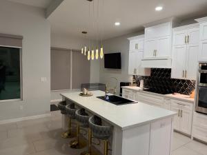 a kitchen with white cabinets and a island with bar stools at Rabbit Run Home in Alton +27 photos