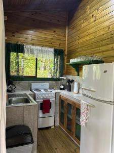 a kitchen with a white stove and a refrigerator at CASITAS GINGER in Quepos