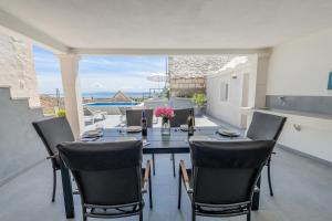 a dining room with a table and chairs on a patio at Authentic Dalmatian stone villa in Selca
