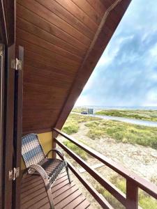 a chair sitting on a porch with a view of the beach at Chalé Horizonte do Silva in Arroio do Silva