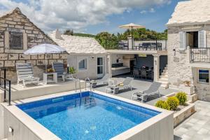 a villa with a swimming pool and a house at Authentic Dalmatian stone villa in Selca