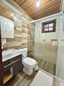 a bathroom with a toilet and a sink and a shower at Chalé Horizonte do Silva in Arroio do Silva +23 photos