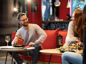a man and woman sitting at a table eating food at Ibis Irun in Irún