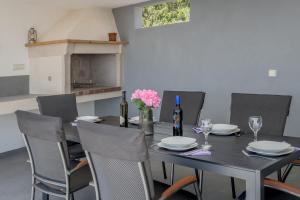 a dining room table with chairs and wine bottles at Authentic Dalmatian stone villa in Selca +69 photos