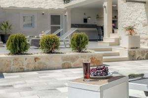 a glass of wine sitting on a table with a bowl of fruit at Authentic Dalmatian stone villa in Selca