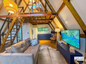 a living room with a couch and a large tv at Chalés Exclusivos com Jacuzzi em Bonito Mato Grosso do Sul in Bonito +87 photos