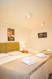 two beds in a hotel room with towels on them at Hotel San Germán de Muñiz in Muñiz