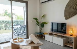 a living room with a television and a table at Palm Beach Studio - New Beach Residence in Saint Martin