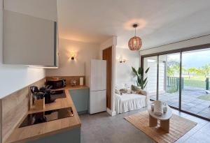 a kitchen with a white refrigerator and a living room at Palm Beach Studio - New Beach Residence in Saint Martin