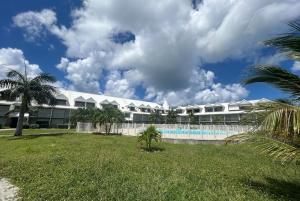 a large building with a swimming pool and palm trees at Palm Beach Studio - New Beach Residence in Saint Martin