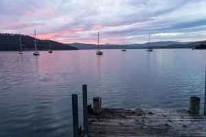 a group of boats on a lake with a dock at Cygnet Cabin in Lymington