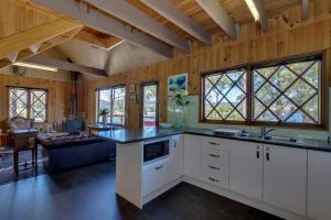 a kitchen with white cabinets and a counter top at Cygnet Cabin in Lymington +26 photos