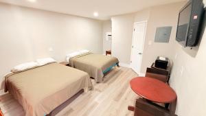 a room with two beds and a flat screen tv at Beachtree Motel in Galveston