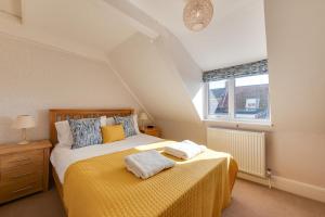 a bedroom with a bed with two towels on it at 4 Bed in Southwold oc-ivy in Southwold