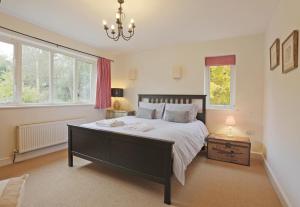 a bedroom with a large bed and a chandelier at 3 Bed in Ufford oc-sfmea in Ufford