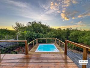 a swimming pool on a wooden deck with avisorvisor at Chalés Exclusivos com Jacuzzi em Bonito Mato Grosso do Sul in Bonito