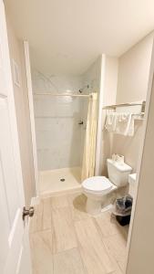a white bathroom with a toilet and a shower at Beachtree Motel in Galveston