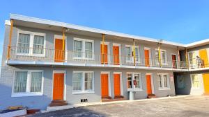 an apartment building with orange doors and a balcony at Beachtree Motel in Galveston