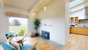 a living room with a fireplace and a table and chairs at Dream Scape in Fort Bragg +28 photos
