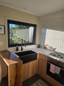 a kitchen with a sink and a window at Estancia del Sol in Putúe