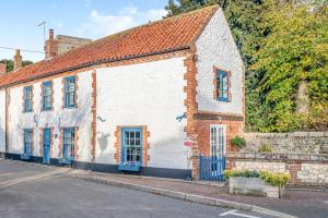 an old white building with blue windows and a street at 3 Bed in Thornham oc-983 in Thornham