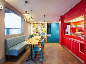 a restaurant with a table and chairs and red cabinets at hotelF1 Montpellier Sud in Lattes