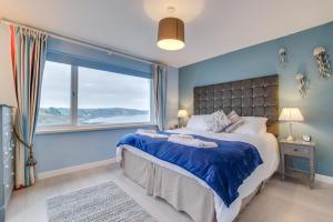 a bedroom with a large bed and a large window at 2 Bed in Looe oc-l10082 in Looe