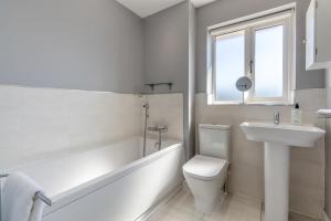 a white bathroom with a tub and a sink and a toilet at 3 Bed in Felixstowe oc-p29748 in Felixstowe