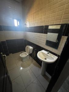 a bathroom with a sink and a toilet at Kantora Red almadie in Dakar