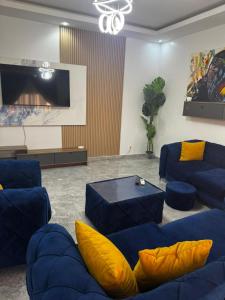 a living room with blue couches and a flat screen tv at Kantora Red almadie in Dakar
