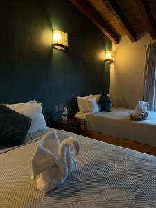 a room with two beds with a swan on the bed at Hotel las Orquideas in Valle de Bravo