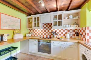 a kitchen with white cabinets and a checkered wall at 2 Bed in Thwaite oc-ds946 in Thwaite