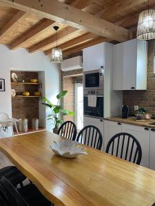 a kitchen with a wooden table and chairs in a kitchen at Casa das Andorinhas - AL in Castelo de Vide